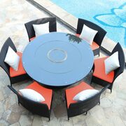 Black 7-piece rattan outdoor dining set with orange and white cushions