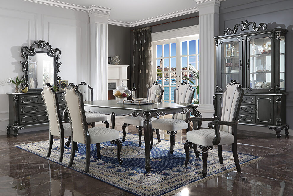 Charcoal finish decorative carvings and silver trim accent dining table by Acme