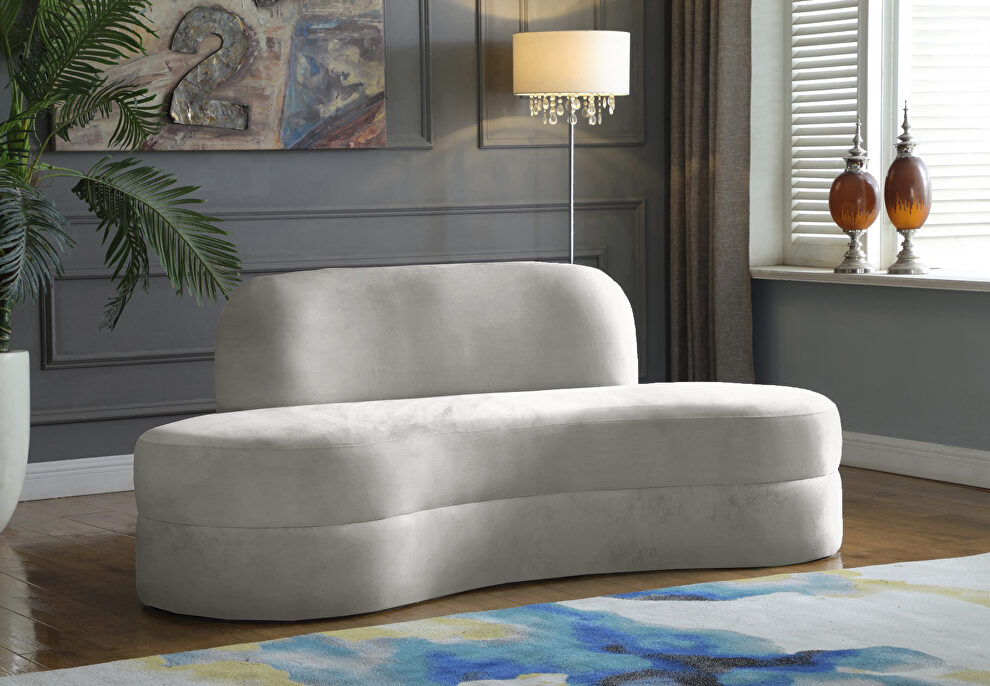 Kidney-shaped lounge style cream velvet sofa by Meridian