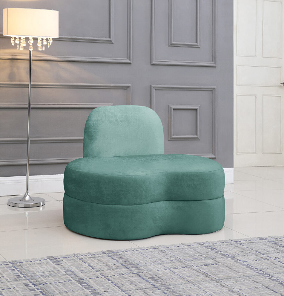 Kidney-shaped lounge style green velvet chair by Meridian