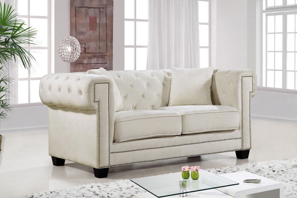 Cream fabric tufted seat & back loveseat by Meridian