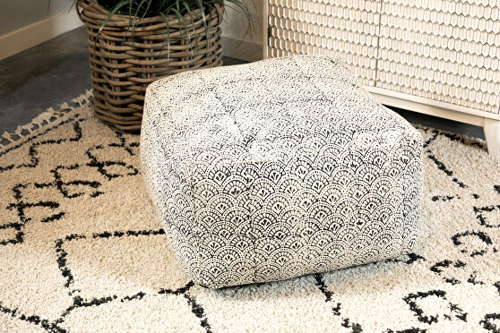 Versatile floor pouf covered in a distressed fabric