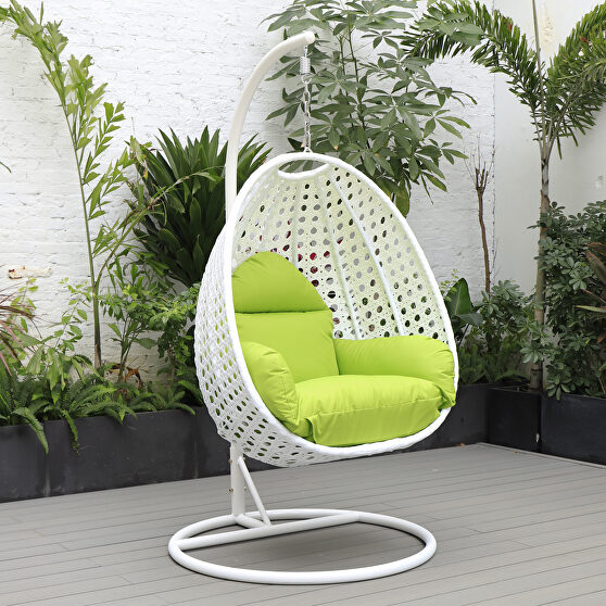 Light green cushion and white wicker hanging egg swing chair