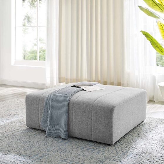 Upholstered fabric ottoman in light gray