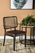 Accent chair crafted with cane backing and framed in black metal