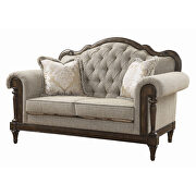 Neutral hued brown fabric loveseat with 2 pillows